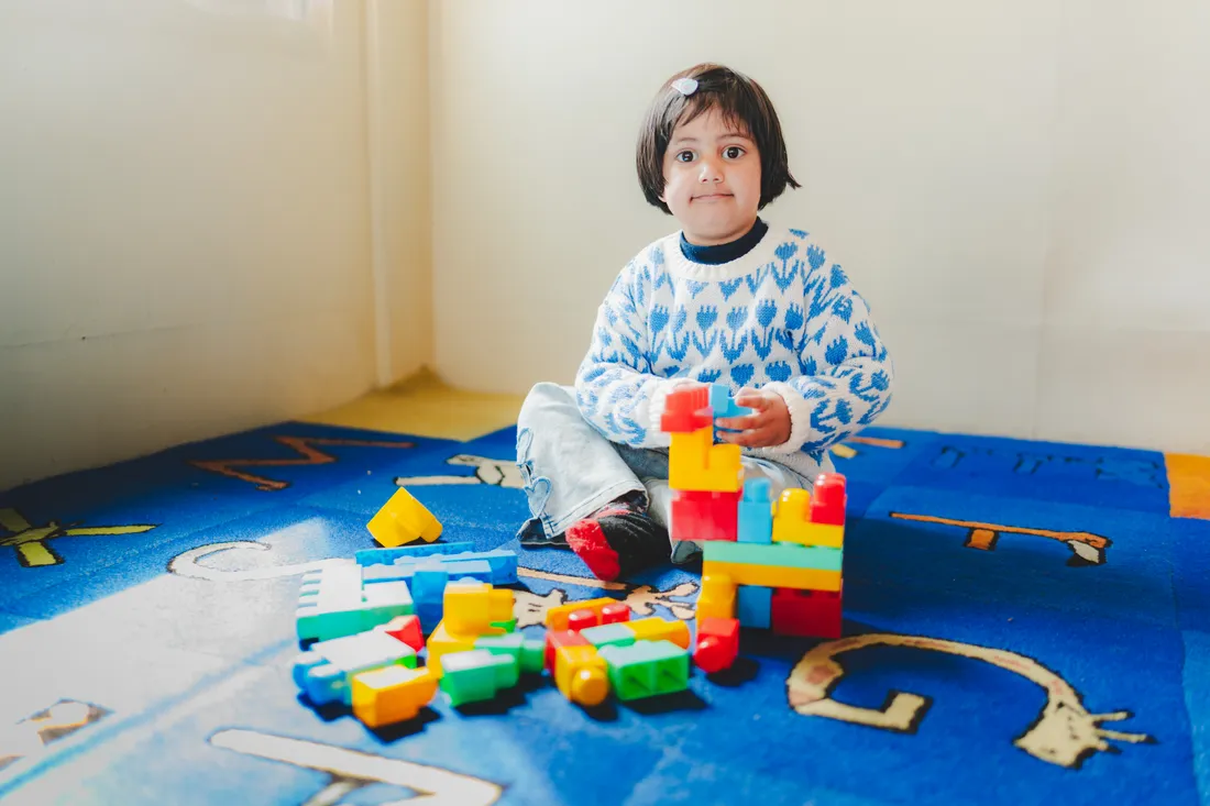 A child playing on the alphabet rug in our bright playroom