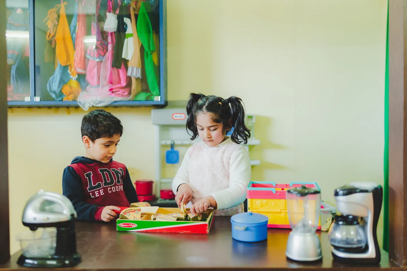 Two children playing together at the toy kitchen