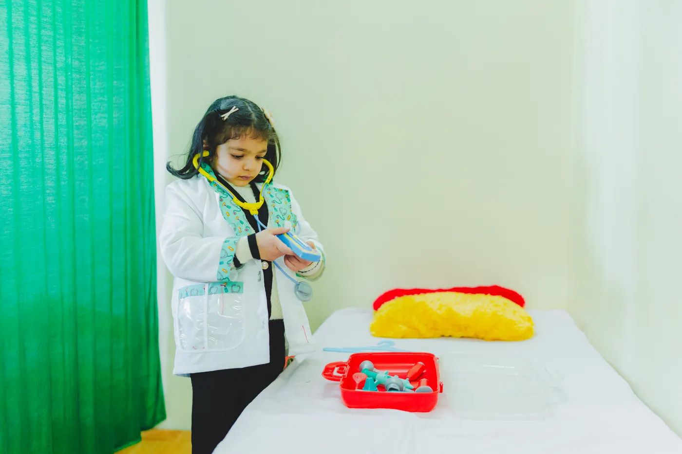 A girl dressed as a doctor exploring a toy medical kit